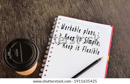 Text on notepad with background of cup of coffee and a pen on wooden table