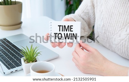 Text on notepad Time to win in hands female. Business Concept