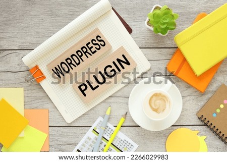 text on wooden blocks. cup of coffee, orange notepad, potted plant. WORD PRESS PLUGIN