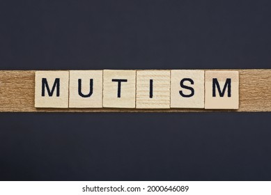 text on word mutism from gray wooden letters on a black background