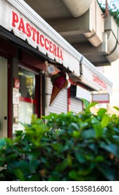 Text Pasticceria On Sunblind. Italian Pastry Shop. Facade On Pastry Shop.  Green Foliage In Front Of Cafe And Sweets Shop.