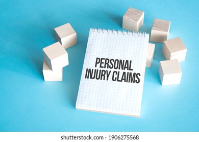 Text Personal Injury Claims On White Notepad With Cube Block, Stock Concept.