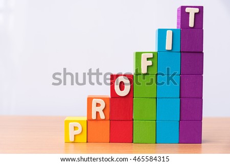 text PROFIT on growing stack of colorful wood cube building blocks