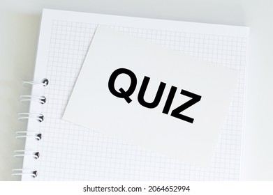 Text QUIZ on card on office desk.