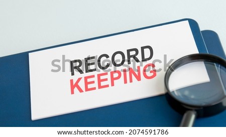 text record keeping on white paper card, black ahd red letters. lens on blue background. business concept. education concept.