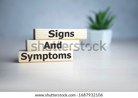 text Signs and SYMPTOMS on wooden cubes, medical concept.