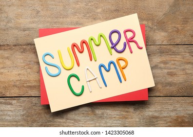 Text SUMMER CAMP Made Of Modelling Clay On Wooden Table, Flat Lay