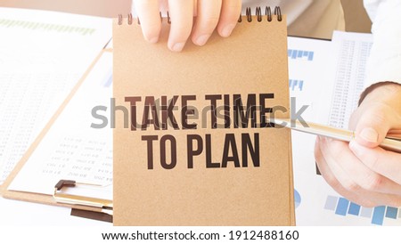 Text take time to plan on brown paper notepad in businessman hands on the table with diagram. Business concept