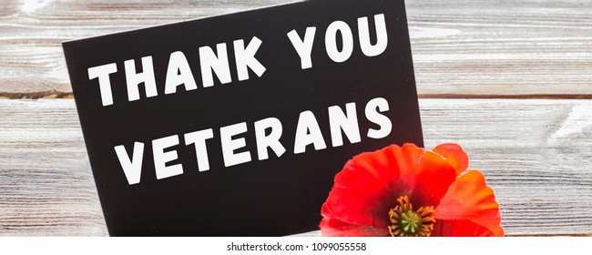 The Text Thank You Veterans Written In A Chalkboard And Red Poppy On A Rustic Wooden Background