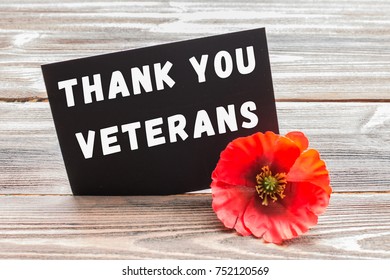 The Text Thank You Veterans Written In A Chalkboard And Red Poppy On A Rustic Wooden Background