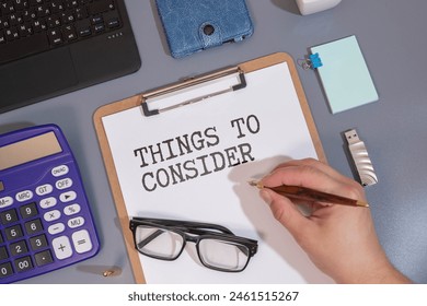 Text THINGS TO CONSIDER on brown paper notepad on the table with diagram. Business concept