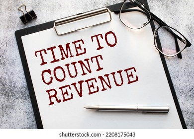 Text Time To Count Revenue on financial tables with pen, glasses and paper clips. Business and financial conzept - Shutterstock ID 2208175043