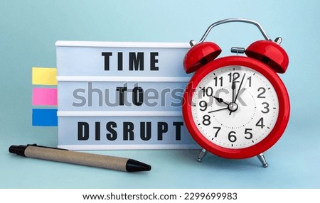 Text TIME TO DISRUPT written on the lightbox with alarm clock and colorfull stickers on blue background