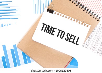 Text TIME TO SELL On White Paper Sheet And Brown Paper Notepad On The Table With Diagram. Business Concept