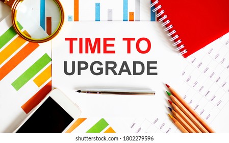 Text TIME TO UPGRADE on notepad with office tools, pen on financial report