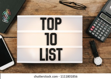Text Top 10 written in vintage style light box on office desktop, high angle birds eye view