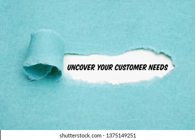 Text Uncover Your Customer Needs appearing behind torn paper. Concept about the importance to understand the demands, requirements and expectations of your clients.