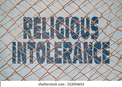 Text Under A Wire Netting About Religious Intolerance And Violence