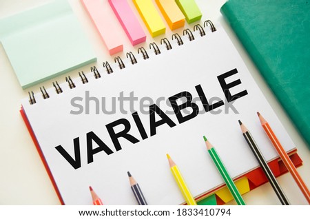 text The variable is written in a notepad. Variable universal life insurance. the text is written on a white piece of paper. in the lens of a calculator and pens. High quality photo