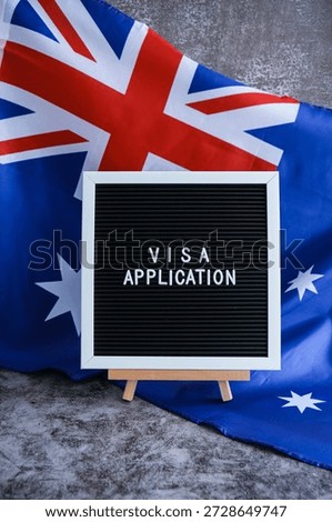 Text VISA APPLICATION on background of waving Australian flag made from silk. Concept of tourism and traveling. Inviting greeting card, advertisement
