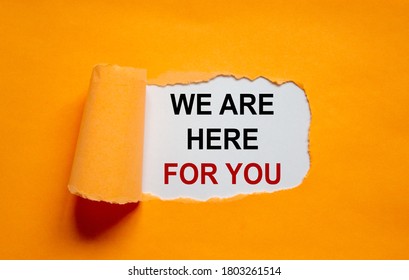 The Text 'we Are Here For You' Appearing Behind Torn Orange Paper. Business Concept. Copy Space.