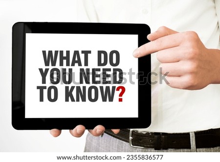 Text WHAT DO YOU NEED TO KNOW on tablet display in businessman hands on the white background. Business concept