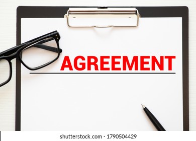 Text, word AGREEMENTS is written on a folder lying on documents on an office desk. Business concept.
