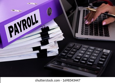 Text, Word Payroll Is Written On A Folder Lying On Documents On An Office Desk With A Laptop And A Calculator. Business Concept.