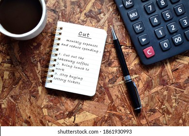 Text Written On Note Pad With Background Of Cup Of Coffee ,a Pen And Calculator. Reduce Expenses Concept