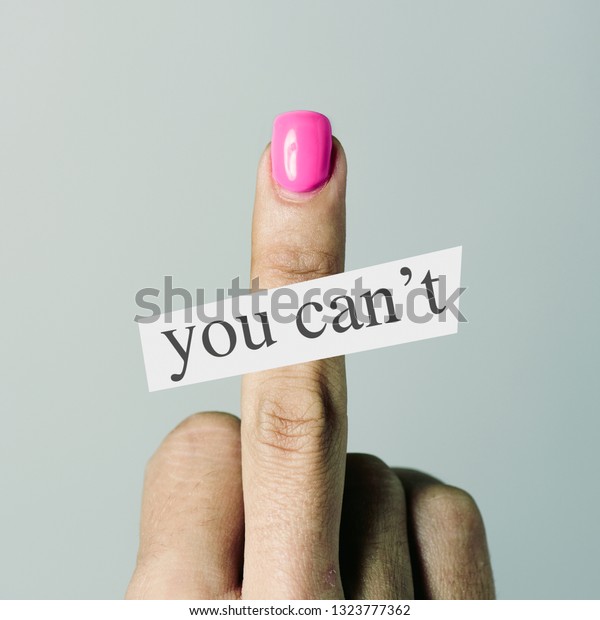 the text you can not and the hand of a young caucasian woman, with her nails painted pink, giving the middle finger, as a gesture of disapproval