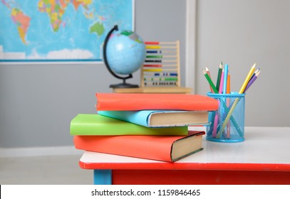 Textbooks and color pencils on the school desk - close-up