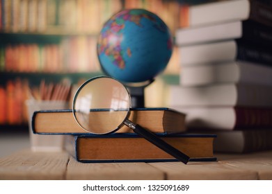 Textbooks,  globe and pencils on a wooden background. Educational background 