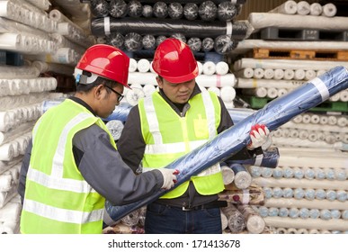 Textile Factory Workers Checking Fabric In Warehouse