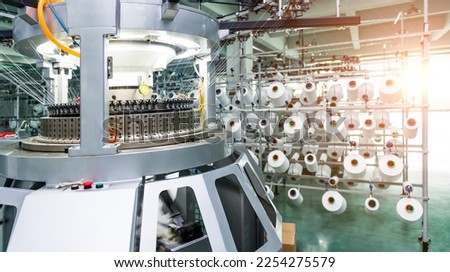 Textile industry - yarn spools on spinning machine in textile factory.