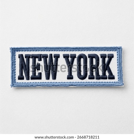 textile patch in the form of the name - New York on a gray background