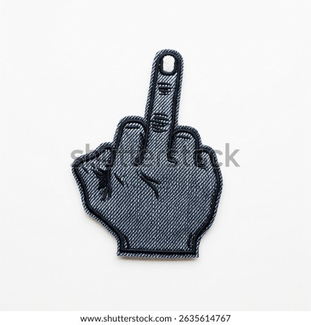 textile patch in the form of a raised middle finger on a white background