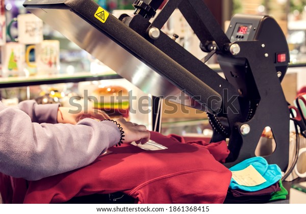 Textile print industry. Man preparing t-short\
for a print in a\
workshop