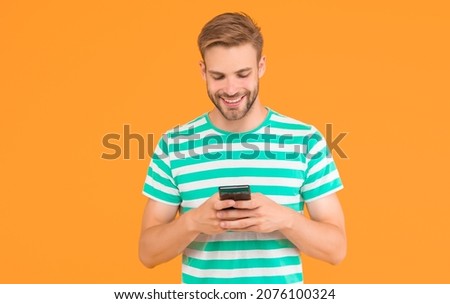 Texting SMS message. Happy guy send sms via smartphone yellow background. Sms messaging. Short message service. New technology. Mobile lifestyle. Modern life. Trusted SMS delivery