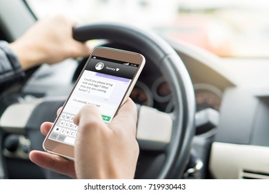 Texting while driving car. Irresponsible man sending sms and using smartphone. Writing and typing message with cellphone in vehicle. Holding steering wheel with other hand.