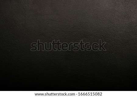 Textural black wall. Black background with a clearly visible texture. Dark background, abstraction, scratches.