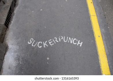 Texture Of Asphalt With Yellow Line And White Word (sucker Punch)