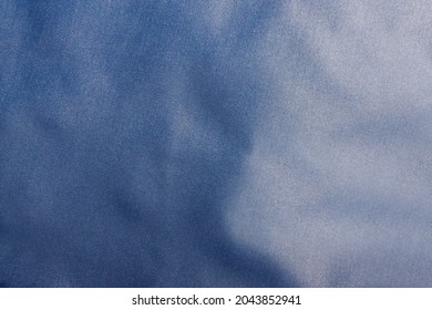 Texture backdrop photo of blue colored and folded bologna fabric.