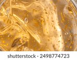 Texture background of the 24k gold skin care cream gel with golden particles for aged skin. Beauty product texture presentation macro