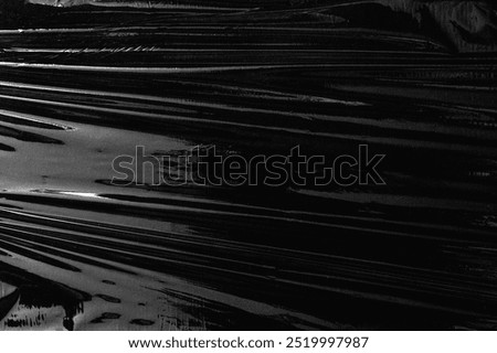 Texture background, black plastic. Plain dark black background, simple desktop background with cellophane. Cool black wallpaper background. Plastic sheet overlay on black backdrop.