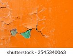 Texture background of bright orange peeling paint, colorful and bright peeling paint of orange color on the rough concrete surface, peeling paint texture with streaks