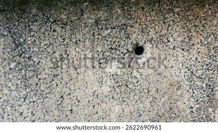 Texture background of cement block wall with small holes drilled in it.