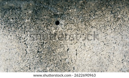 Texture background of cement block wall with small holes drilled in it.