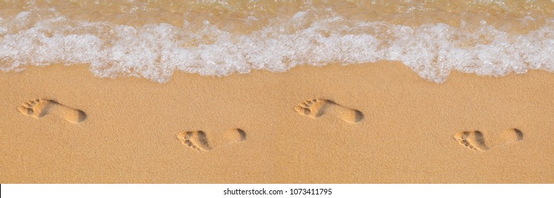 Texture background Footprints of human feet on the sand near the water on the beach