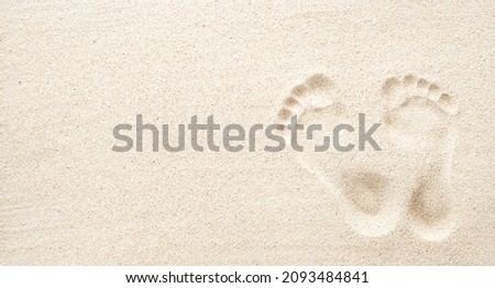 Texture background Footprints of human feet on the sand, top view with copy space 