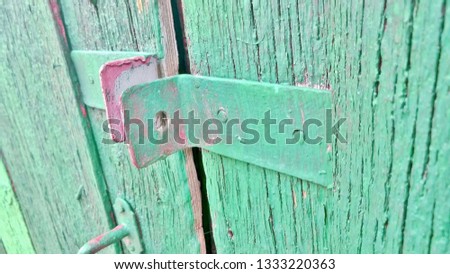 Texture and background, image, wallpaper of old green iron metal door hinges for a padlock on a wooden door, wall, any other space.